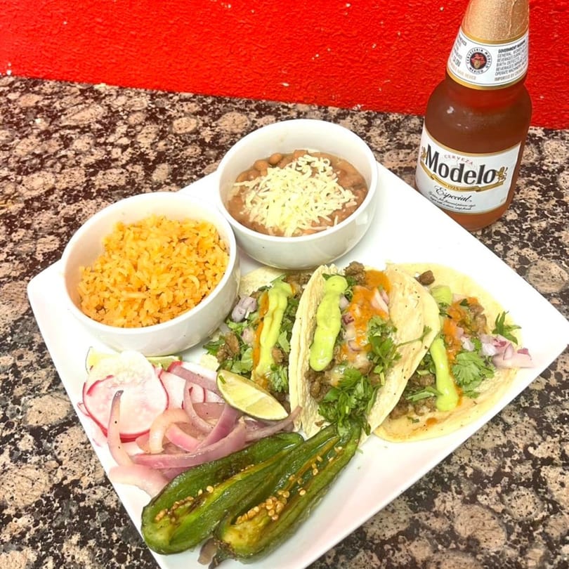 My Taco House plate with three tacos, rice, beans, jalapeños, and a Modelo beer.