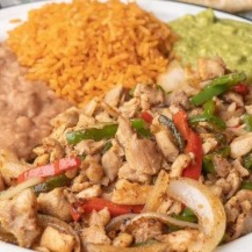 Chicken fajitas with bell peppers and onions, served with rice, refried beans, and guacamole.